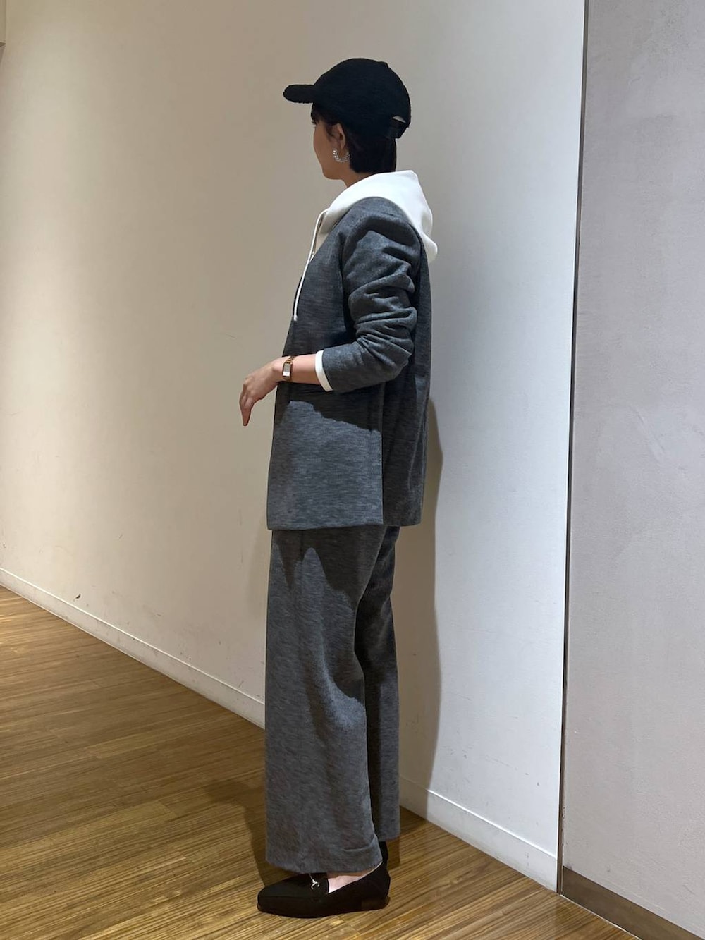ブラック系のショルダーバッグ、ホワイト系のパーカー、グレー系のスラックスを着用したレディースの秋コーディネートの3枚目の写真