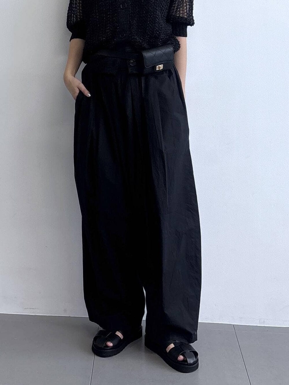 ブラック系のその他パンツ、ブラック系のニット/セーター、ブラック系のショルダーバッグを着用したレディースの冬コーディネートの3枚目の写真