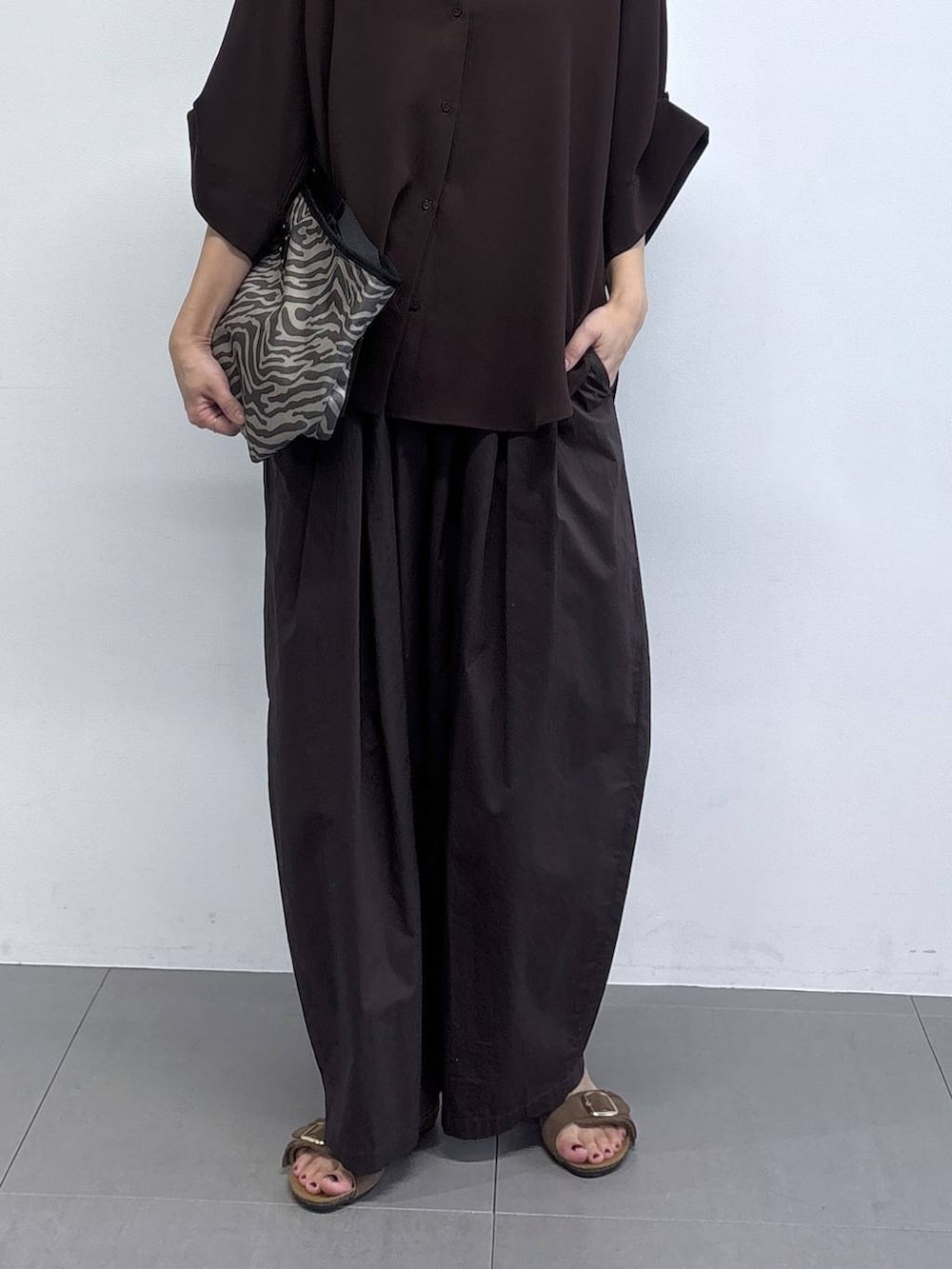 ブラウン系のその他パンツ、グレー系のトートバッグ、ブラウン系のサンダルを着用したレディースの春コーディネートの4枚目の写真