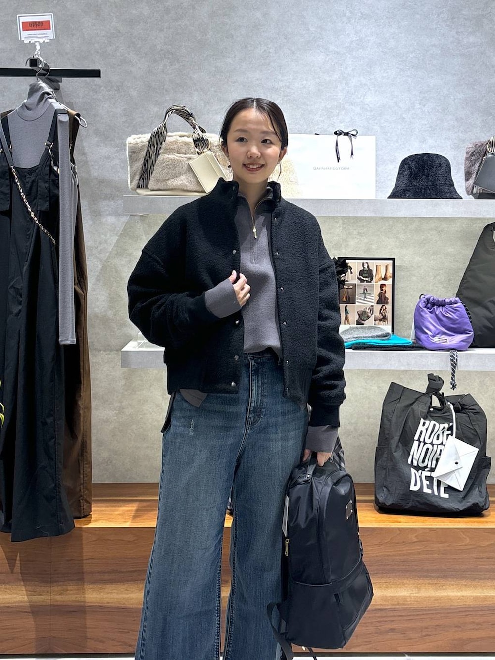 ブラック系のバックパック/リュック、ブラック系のブルゾン、ブルー系のデニムパンツを着用したレディースの冬コーディネートの3枚目の写真