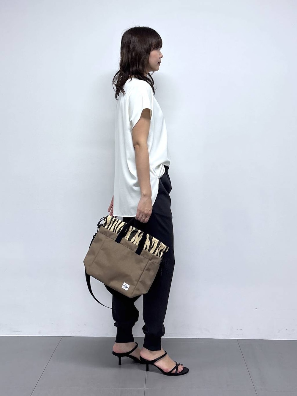 ホワイト系のシャツ/ブラウス、ブラック系のサンダル、グレー系のその他パンツを着用したレディースの春コーディネートの3枚目の写真