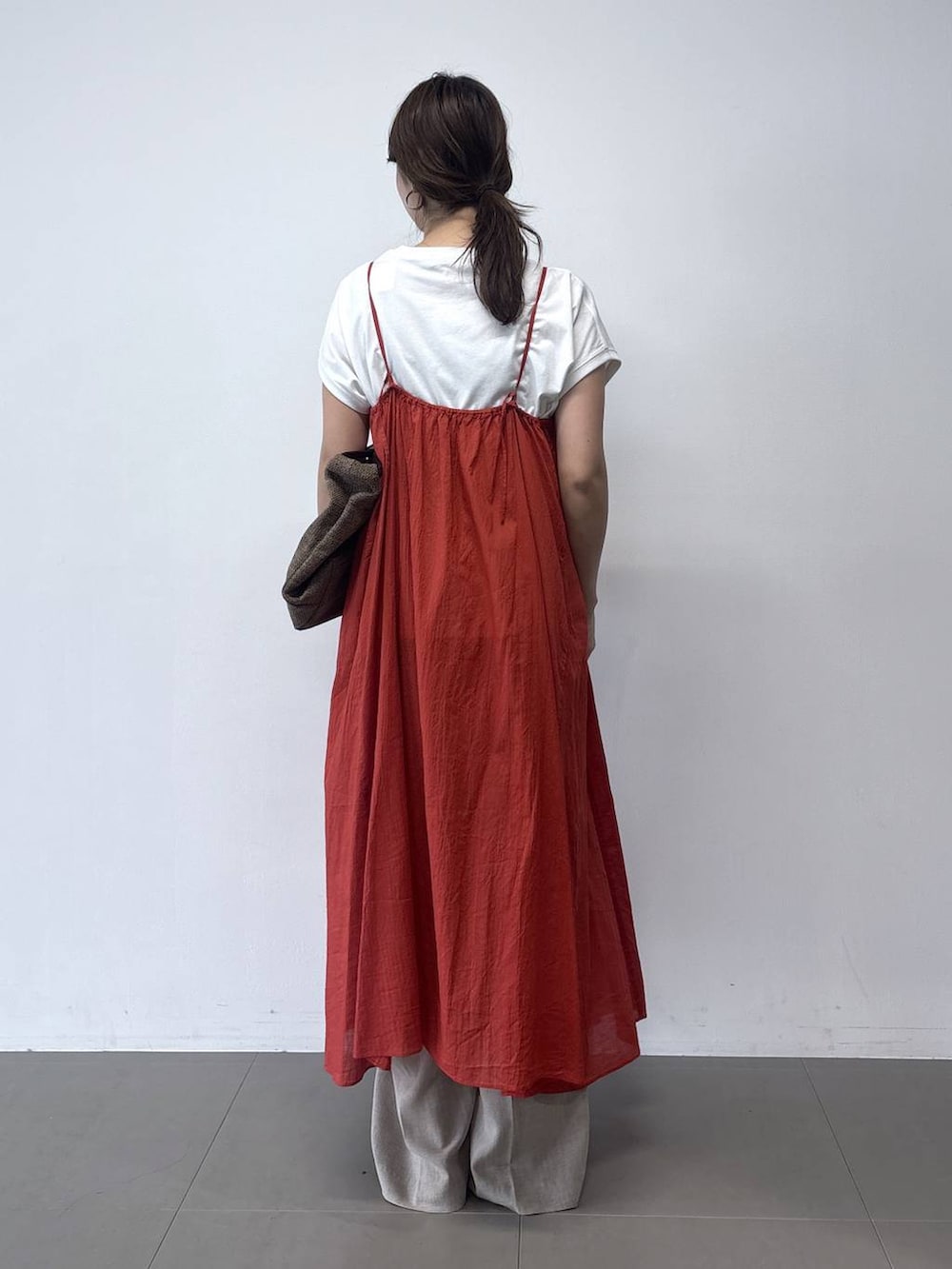 ベージュ系のその他パンツ、オレンジ系のワンピース、ブラウン系のトートバッグを着用したレディースの春コーディネートの4枚目の写真