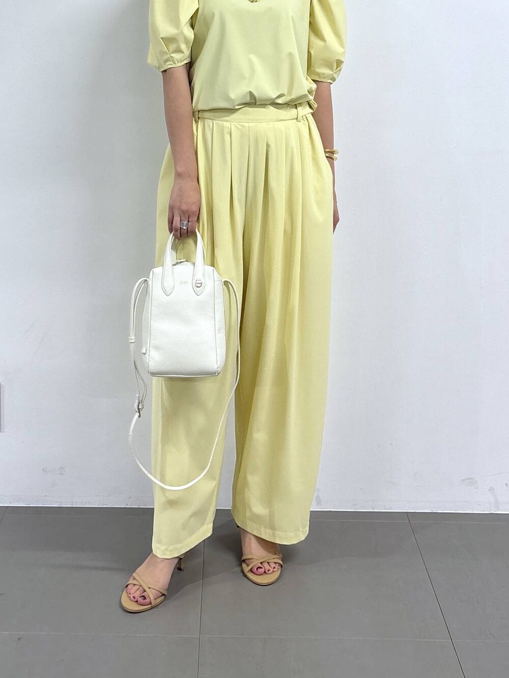 イエロー系のシャツ/ブラウス、ホワイト系のショルダーバッグ、イエロー系のその他パンツを着用したレディースの春コーディネートの4枚目の写真