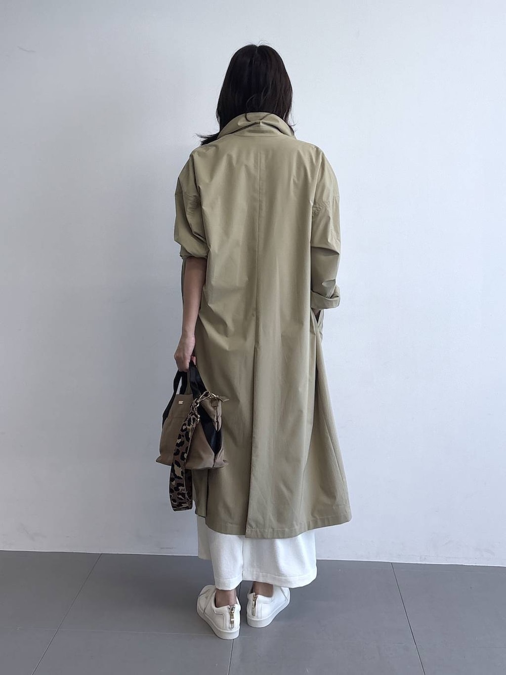 イエロー系のトートバッグ、ホワイト系のベスト、ホワイト系のスニーカーを着用したレディースの冬コーディネートの5枚目の写真