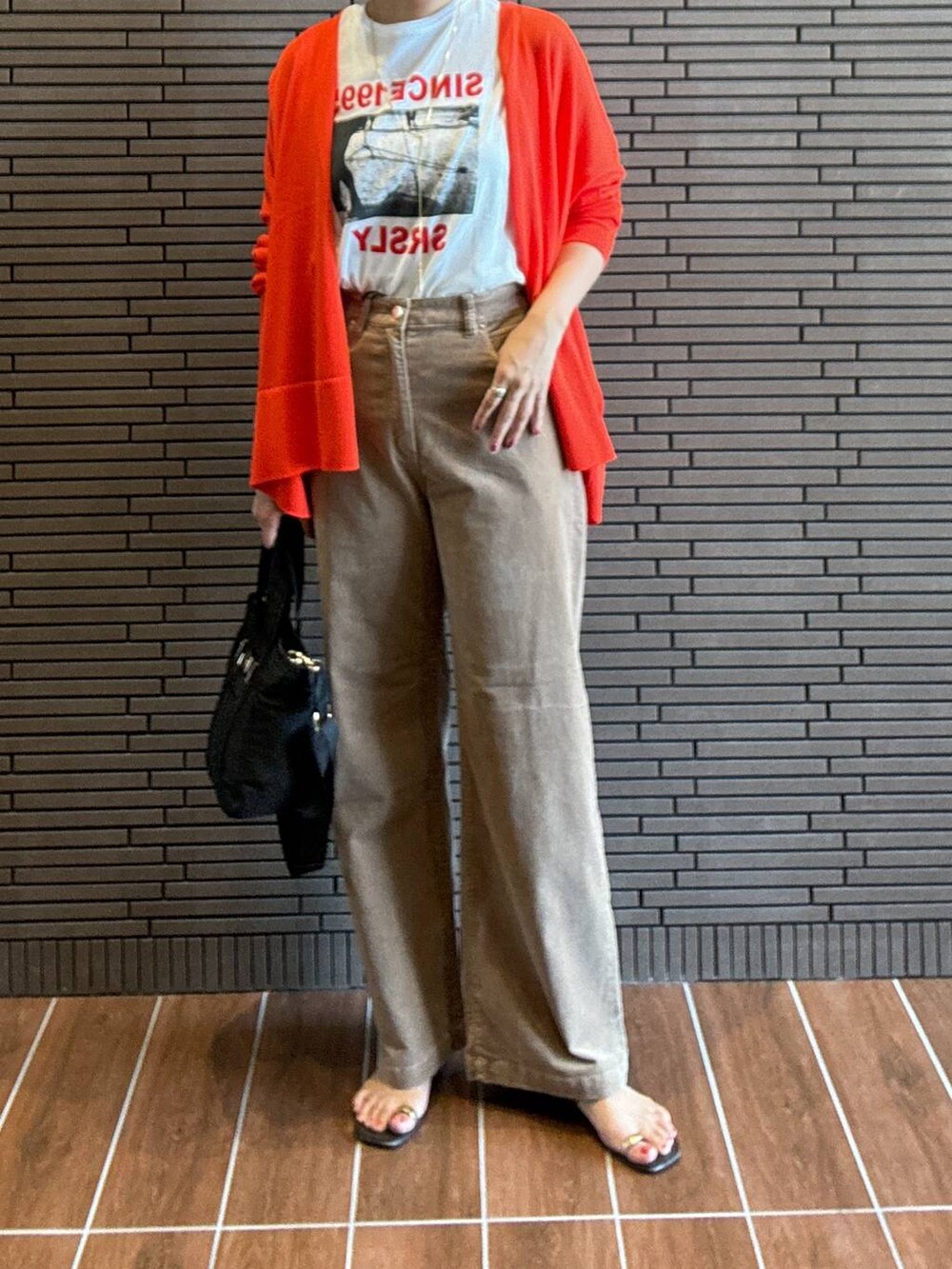 ホワイト系のTシャツ/カットソー、オレンジ系のカーディガン/ボレロ、ブラック系のトートバッグを着用したレディースの夏コーディネートの3枚目の写真