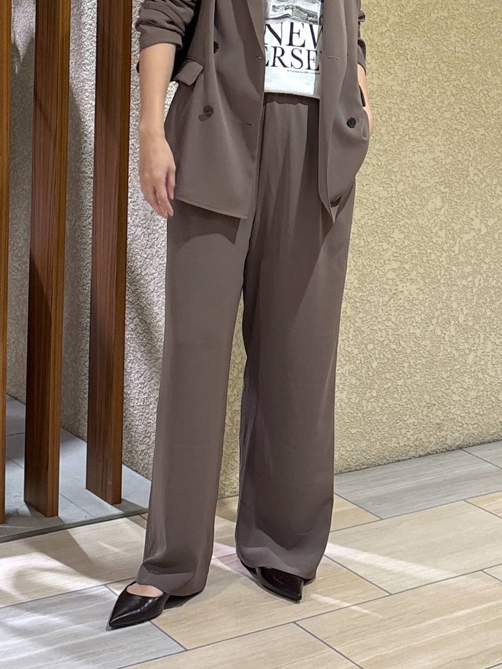 グリーン系のスラックス、グリーン系のテーラードジャケット、ブラック系のハンドバッグを着用したレディースの冬コーディネートの4枚目の写真