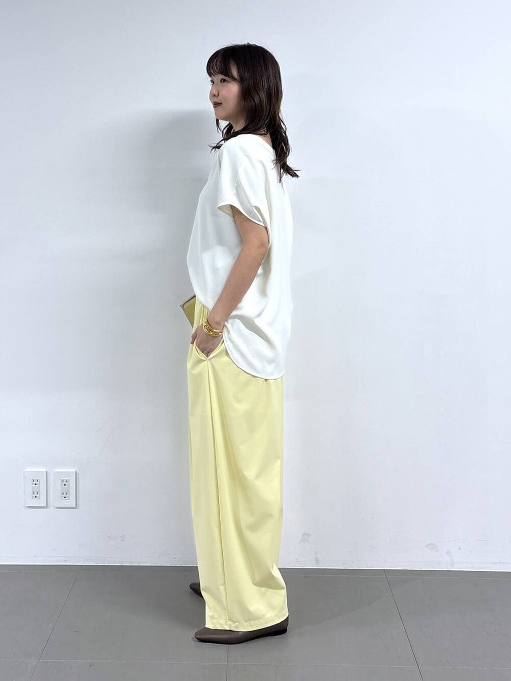 ホワイト系のシャツ/ブラウス、イエロー系のその他パンツ、ブラウン系のパンプスを着用したレディースの春コーディネートの3枚目の写真