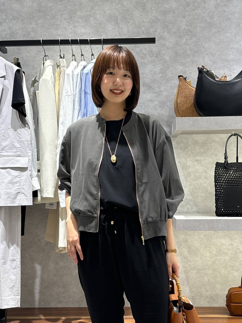 ブラック系のスリッポン、グレー系のブルゾン、ブラック系のTシャツ/カットソーを着用したレディースの春コーディネートの2枚目の写真