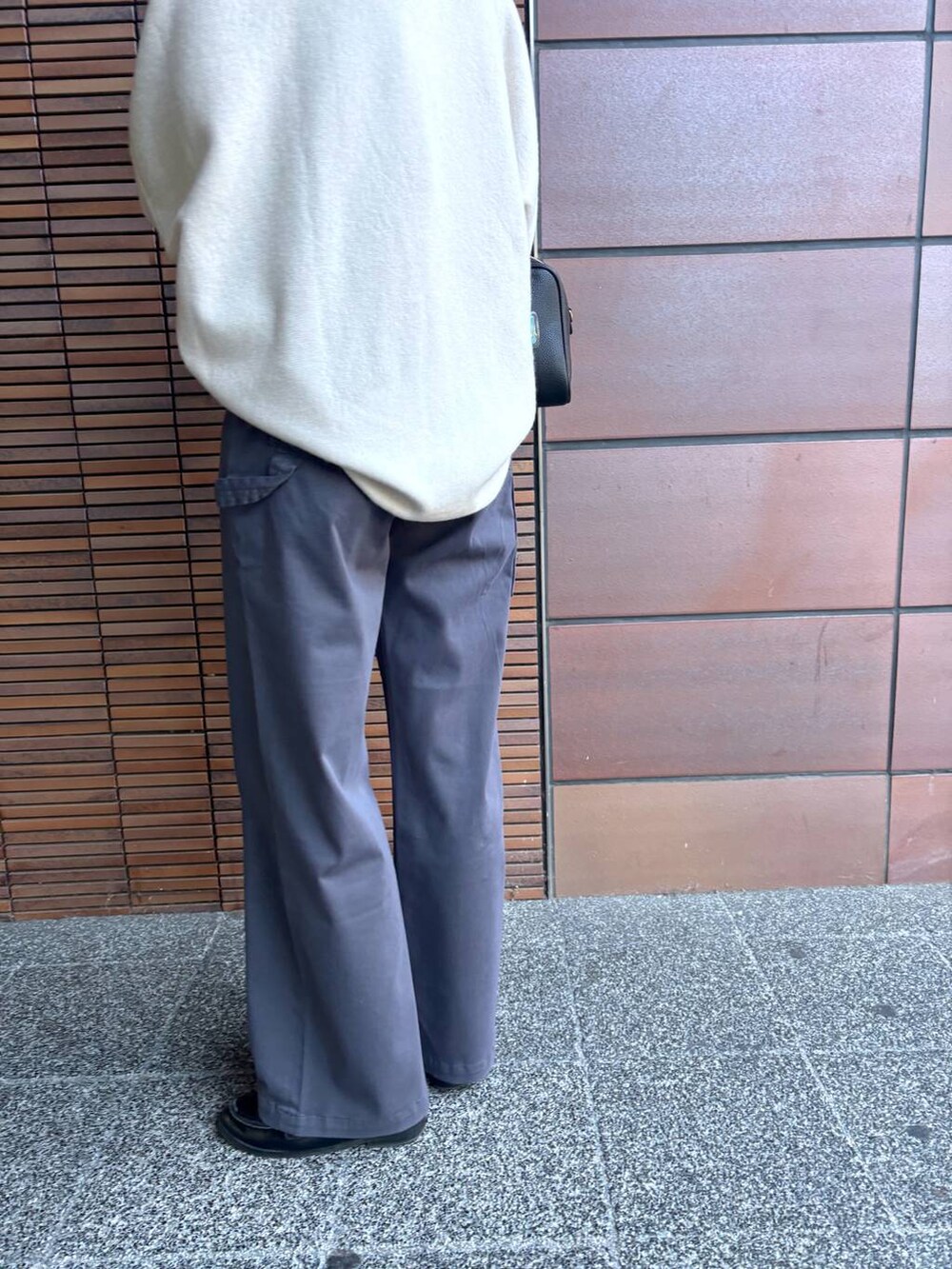 ブラック系のボストンバッグ、ホワイト系のニット/セーター、グレー系のその他パンツを着用したレディースの冬コーディネートの6枚目の写真