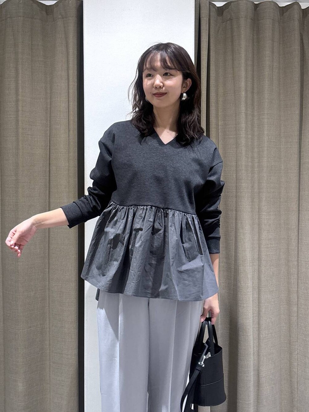 グレー系のその他パンツ、ブラック系のハンドバッグ、グレー系のTシャツ/カットソーを着用したレディースの冬コーディネートの3枚目の写真