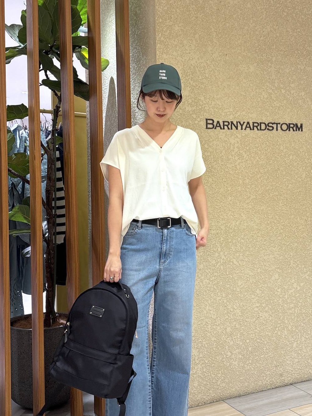 ブルー系のデニムパンツ、ブラック系のバックパック/リュック、ホワイト系のシャツ/ブラウスを着用したレディースの春コーディネートの4枚目の写真