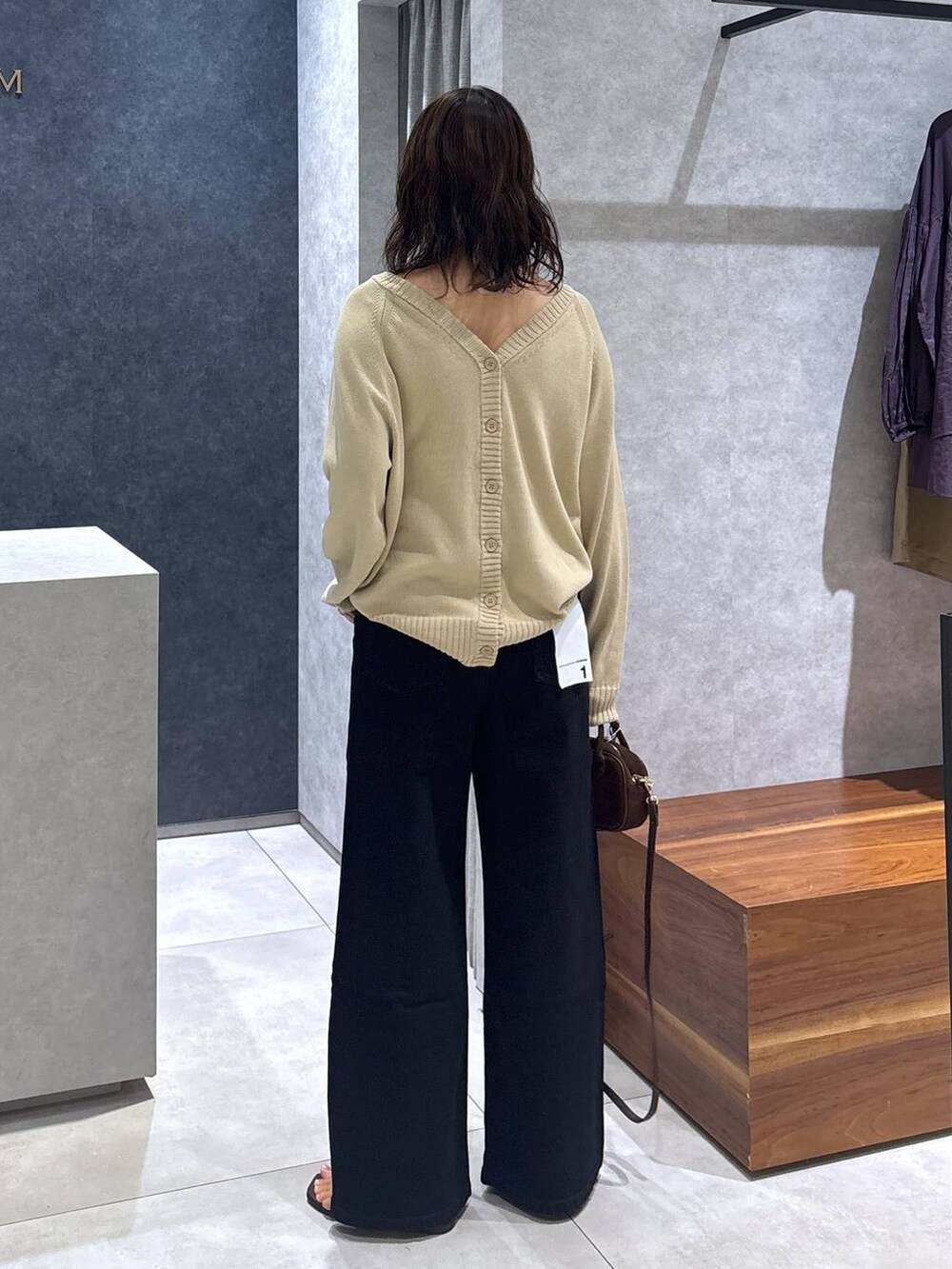 ブラック系のデニムパンツ、ベージュ系のカーディガン/ボレロ、ブラウン系のショルダーバッグを着用したレディースの夏コーディネートの5枚目の写真