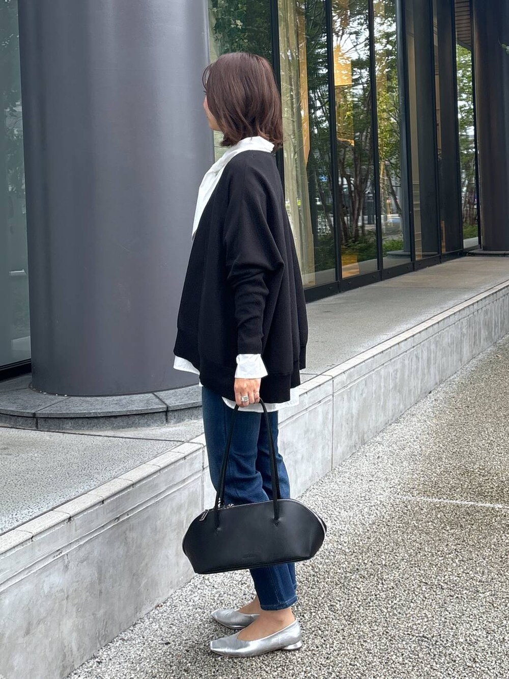 ブラック系のトートバッグ、シルバー系のパンプス、ブラック系のニット/セーターを着用したレディースの秋コーディネートの3枚目の写真