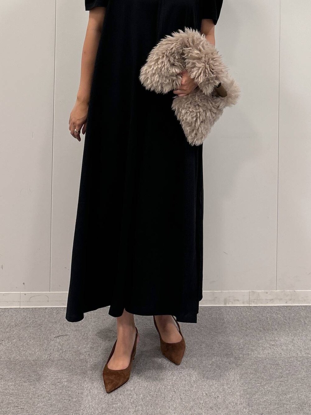 ブラウン系のトートバッグ、ブラック系のワンピース、ブラウン系のパンプスを着用したレディースの秋コーディネートの5枚目の写真