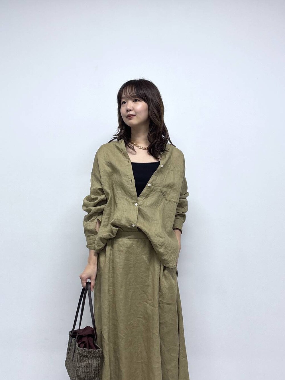 ベージュ系のシャツ/ブラウス、ベージュ系のスカート、ブラック系のサンダルを着用したレディースの春コーディネートの3枚目の写真