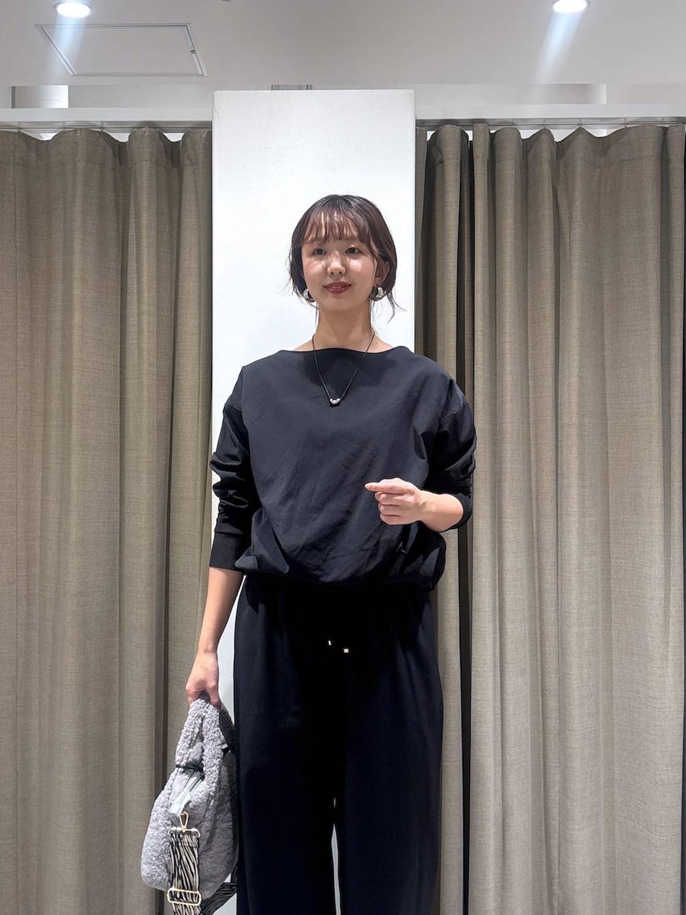 ブラック系のパンプス、グレー系のトートバッグ、ブラック系のTシャツ/カットソーを着用したレディースの秋コーディネートの2枚目の写真