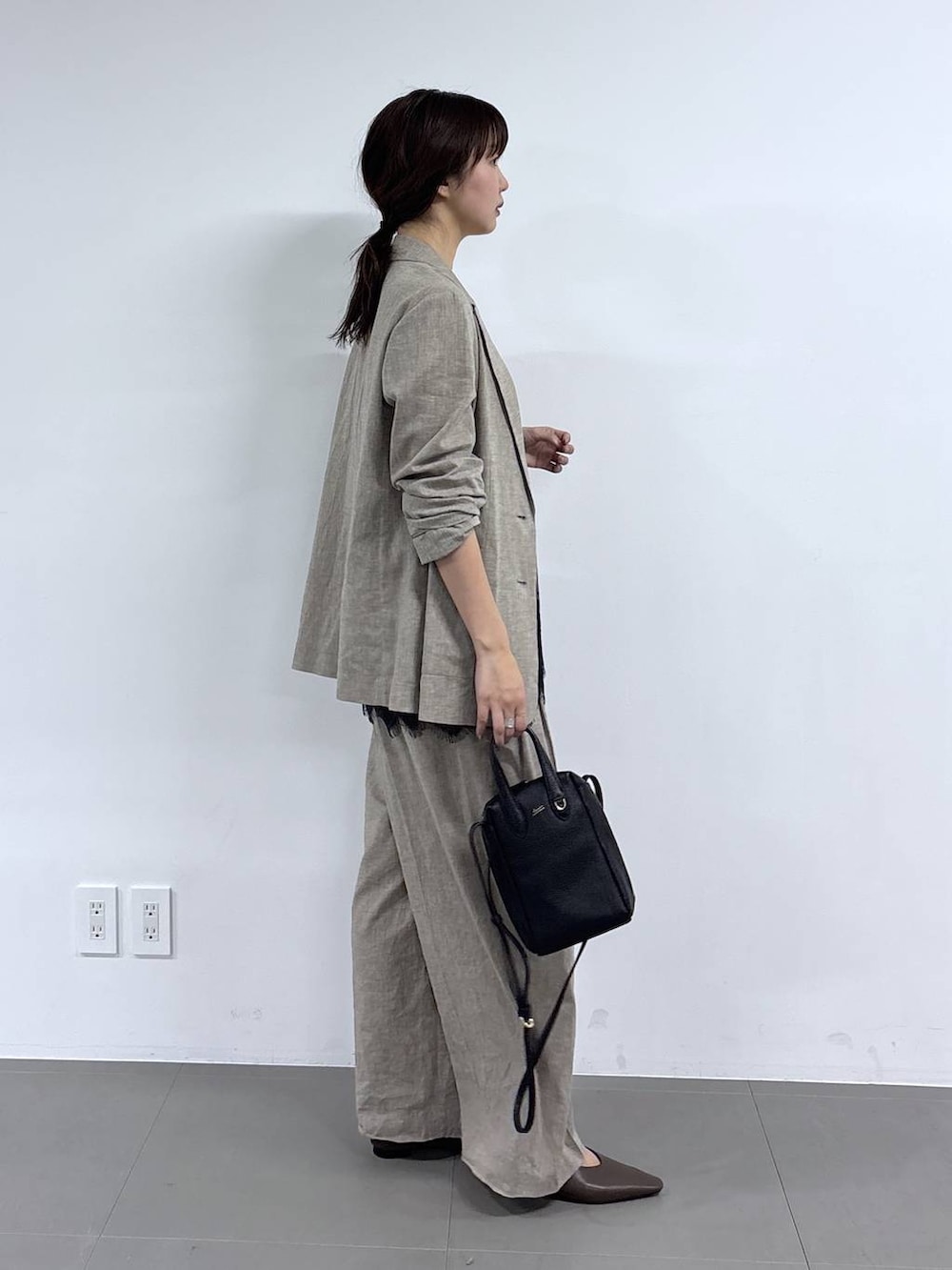 ベージュ系のその他パンツ、ベージュ系のテーラードジャケット、ブラック系のショルダーバッグを着用したレディースの春コーディネートの3枚目の写真