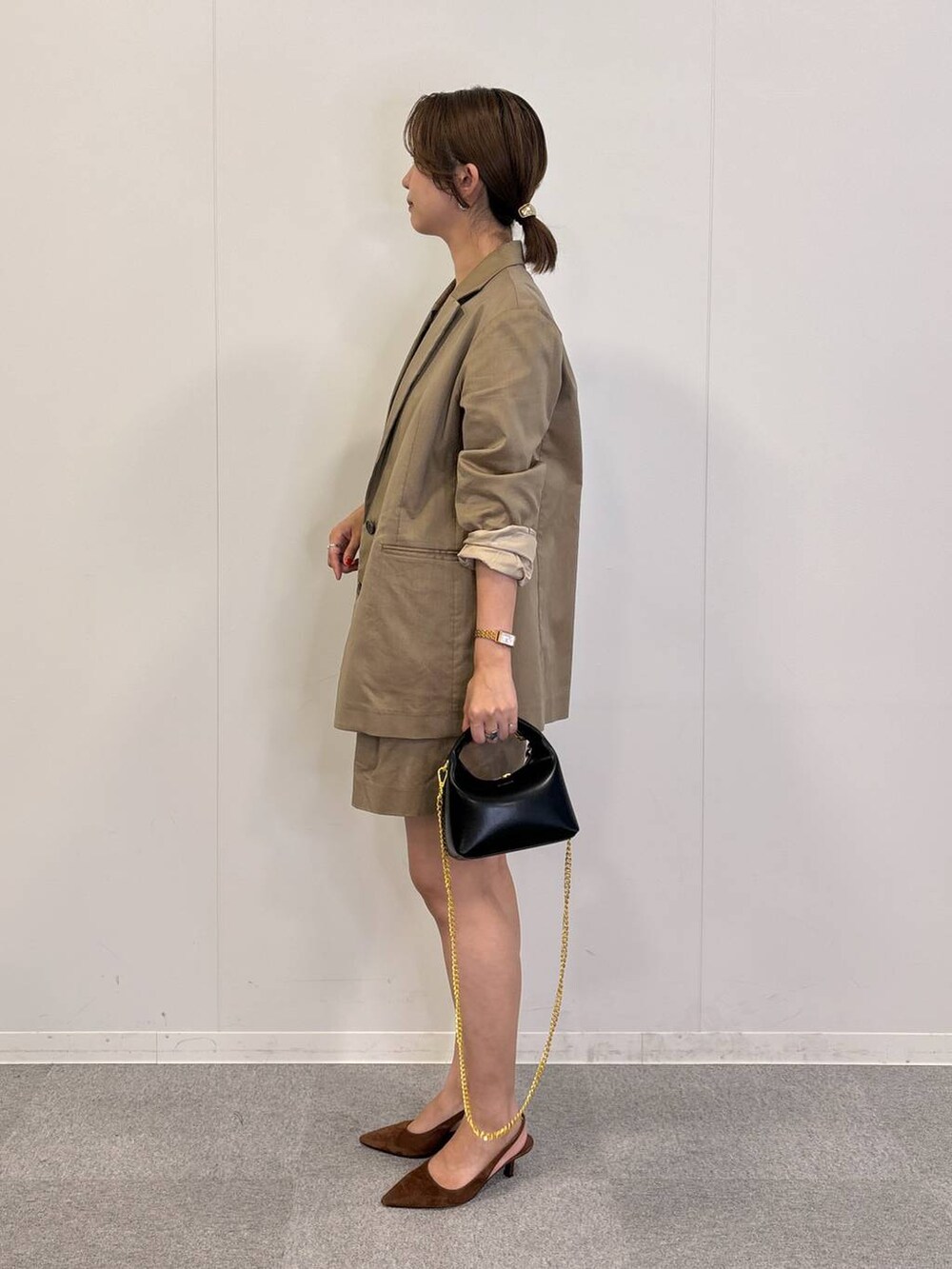 ブラック系のショルダーバッグ、ブラック系のTシャツ/カットソー、ベージュ系のテーラードジャケットを着用したレディースの秋コーディネートの3枚目の写真