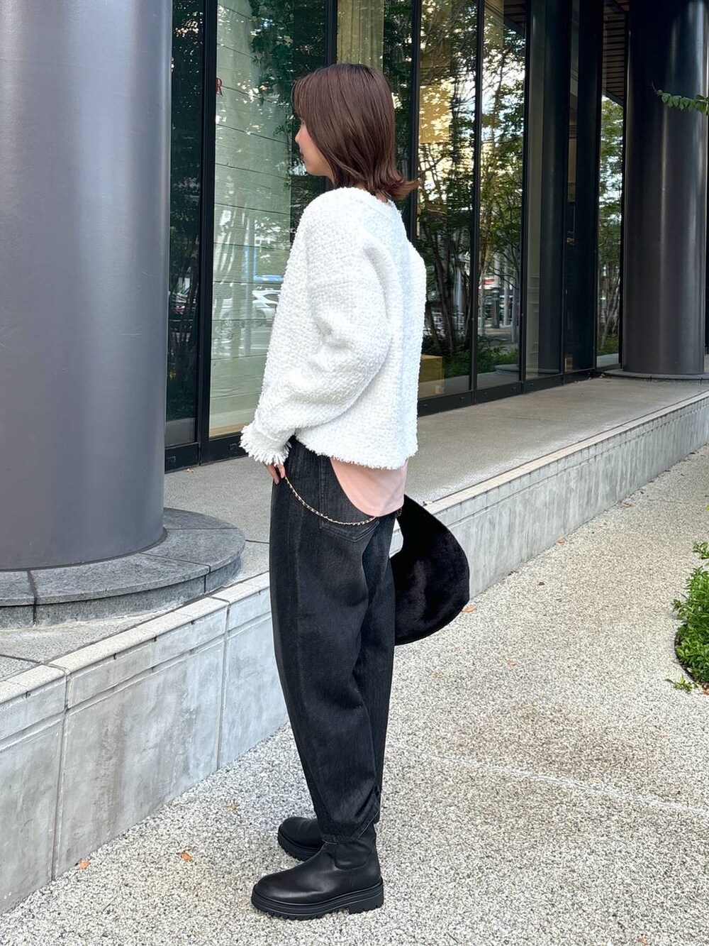 ブラック系のデニムパンツ、ブラック系のブーツ、ブラック系のトートバッグを着用したレディースの秋コーディネートの6枚目の写真