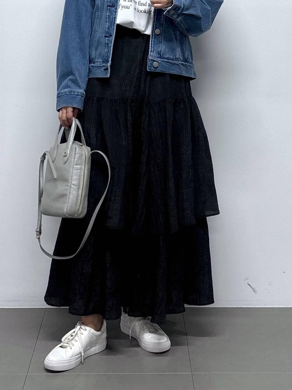 ブルー系のデニムジャケット、ホワイト系のTシャツ/カットソー、ブラック系のスカートを着用したレディースの冬コーディネートの4枚目の写真