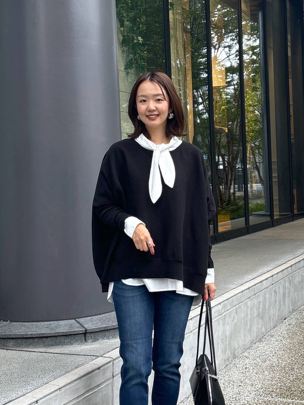 ブラック系のトートバッグ、シルバー系のパンプス、ブラック系のニット/セーターを着用したレディースの秋コーディネートの2枚目の写真