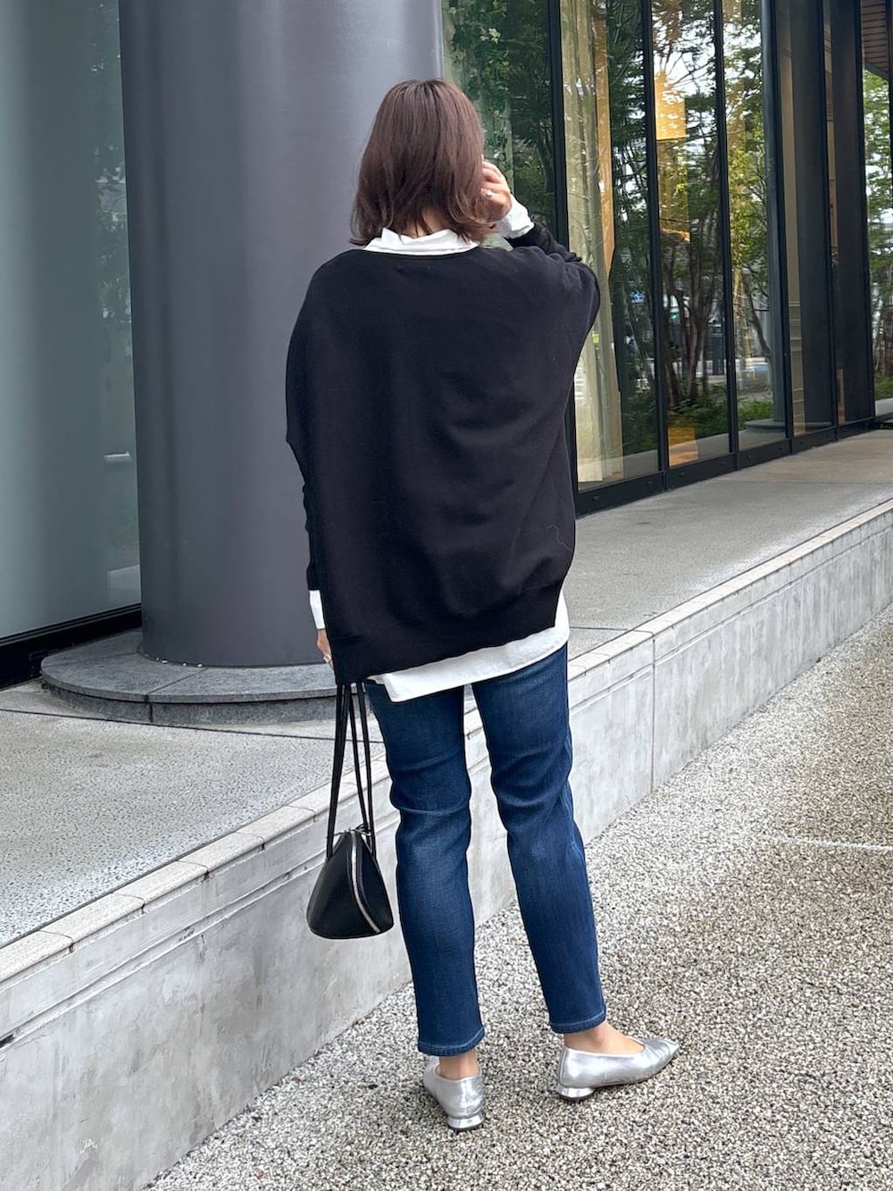 ブラック系のトートバッグ、シルバー系のパンプス、ブラック系のニット/セーターを着用したレディースの秋コーディネートの5枚目の写真