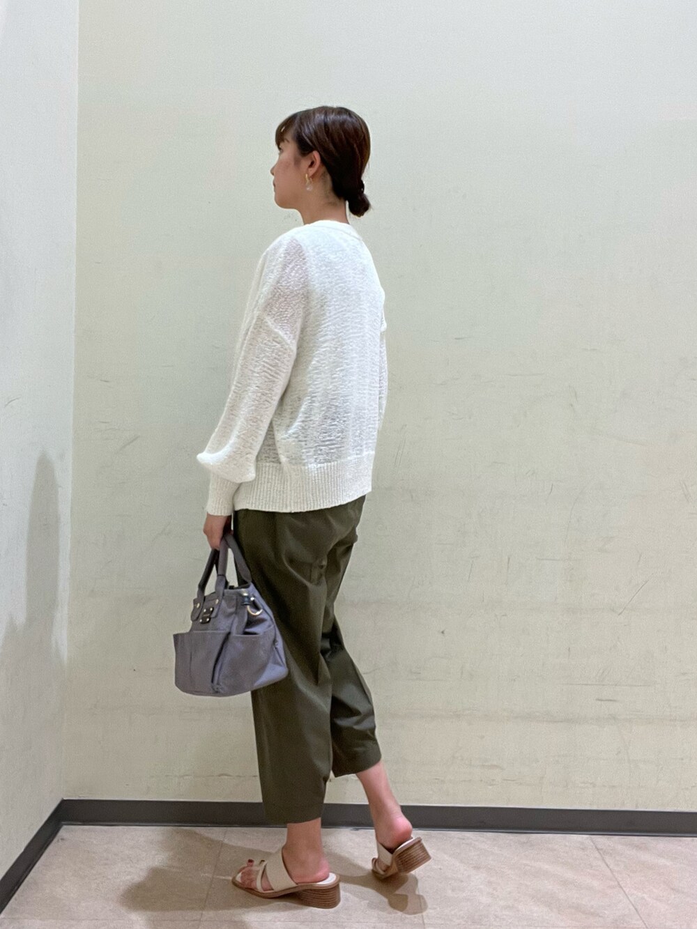 グレー系のトートバッグ、ホワイト系のサンダル、グリーン系のその他パンツを着用したレディースの夏コーディネートの3枚目の写真