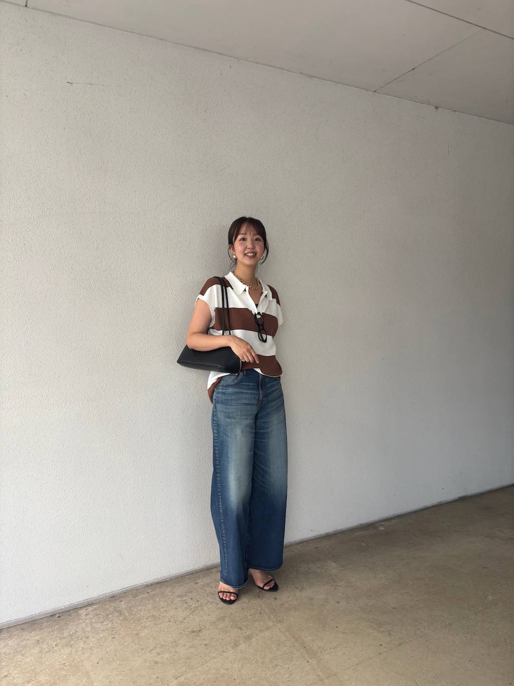 ブルー系のデニムパンツ、ブラック系のトートバッグ、イエロー系のニット/セーターを着用したレディースの夏コーディネートの7枚目の写真