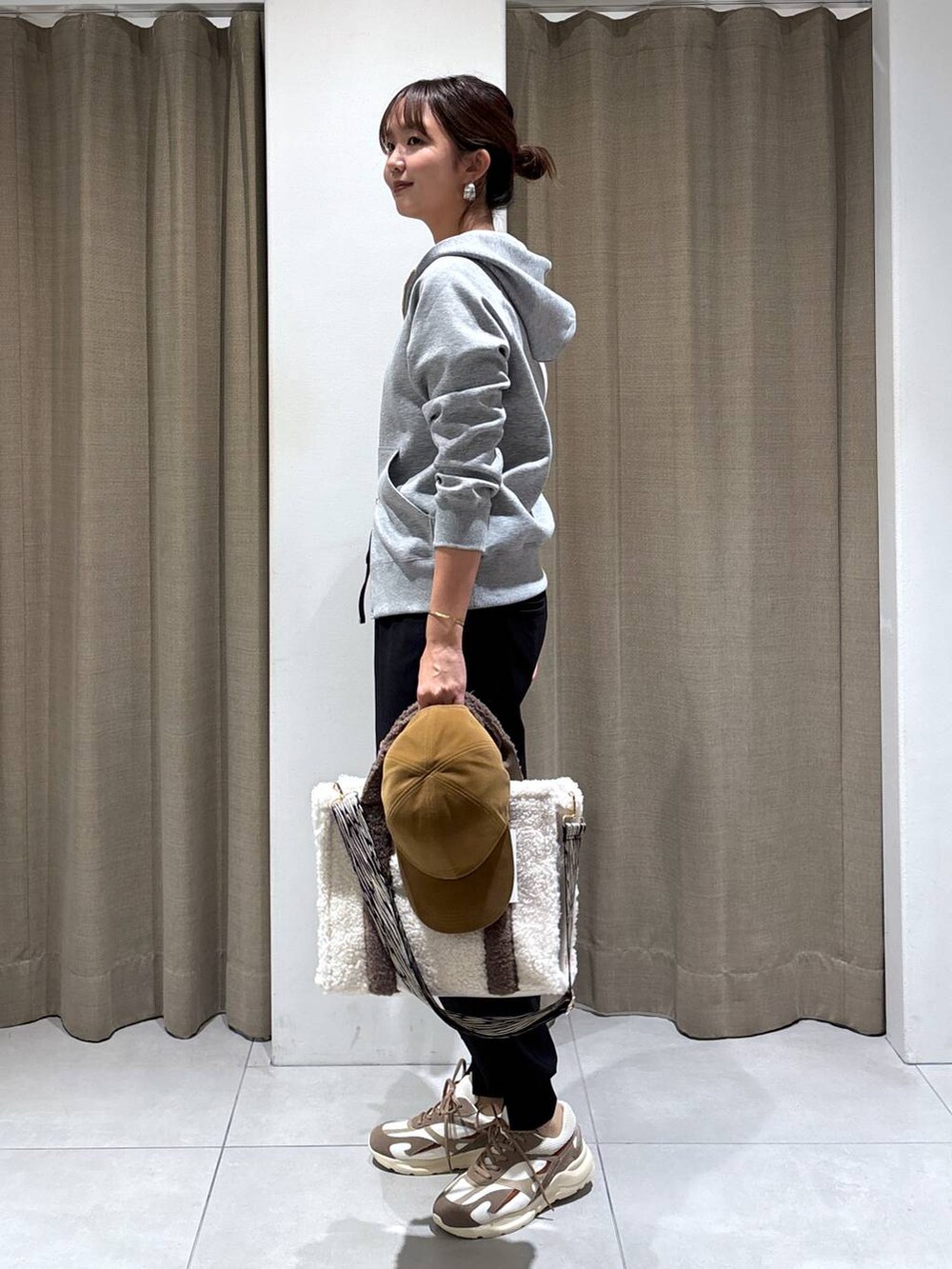 ホワイト系のトートバッグ、ブラック系のその他パンツ、ブラウン系のスニーカーを着用したレディースの秋コーディネートの3枚目の写真