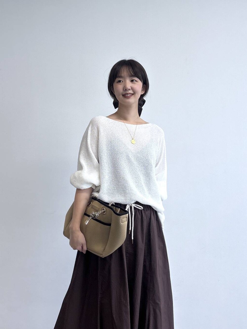 ブラウン系のトートバッグを着用したレディースの冬コーディネートの2枚目の写真