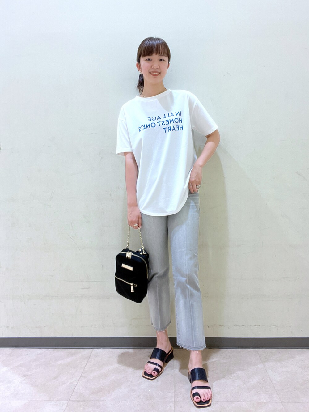 ブルー系のTシャツ/カットソー、ブラック系のボディバッグ/ウエストポーチ、イエロー系のサンダルを着用したレディースの夏コーディネートの2枚目の写真