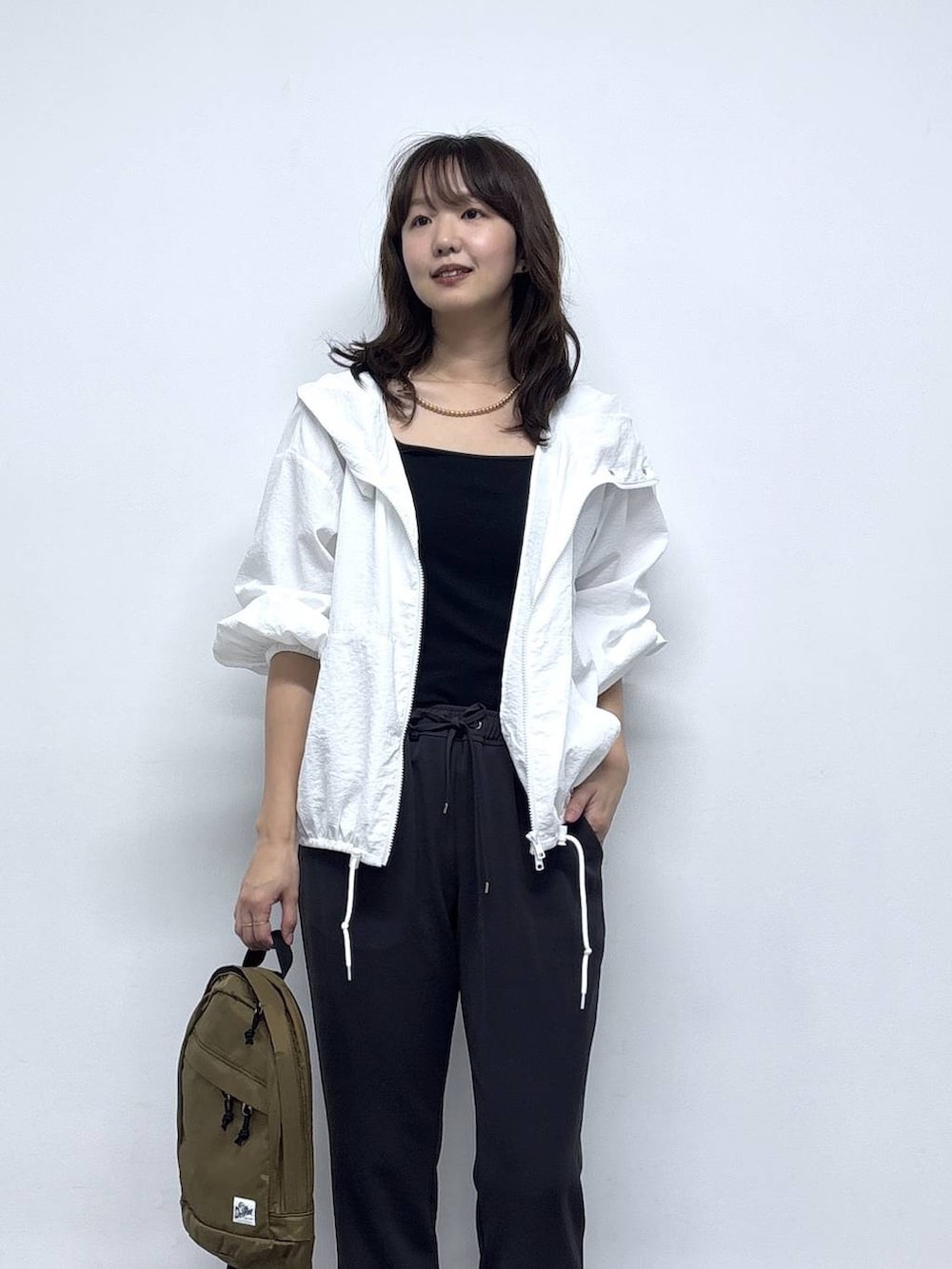 ホワイト系のブルゾン、ブラック系のパンプス、グレー系のその他パンツを着用したレディースの春コーディネートの3枚目の写真