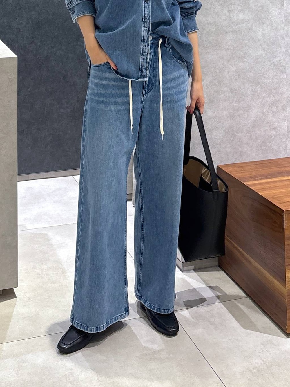 ブルー系のシャツ/ブラウス、ブルー系のデニムパンツ、ブラック系のローファーを着用したレディースの春コーディネートの4枚目の写真