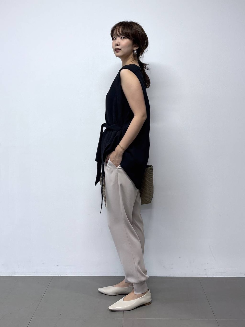 ホワイト系のパンプス、ブラック系のシャツ/ブラウス、ベージュ系のハンドバッグを着用したレディースの夏コーディネートの5枚目の写真