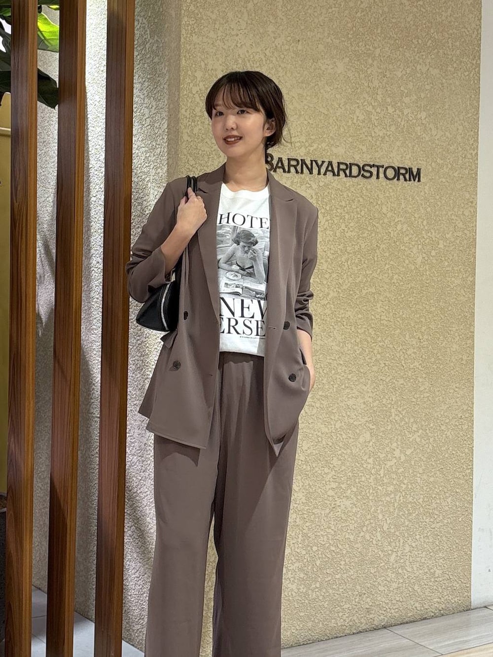 グリーン系のスラックス、グリーン系のテーラードジャケット、ブラック系のハンドバッグを着用したレディースの冬コーディネートの3枚目の写真