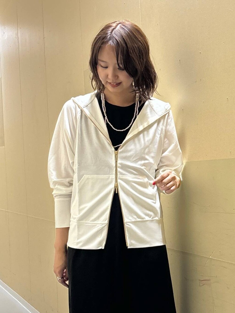 ホワイト系のパーカー、ブラック系のワンピースを着用したレディースの夏コーディネートの2枚目の写真