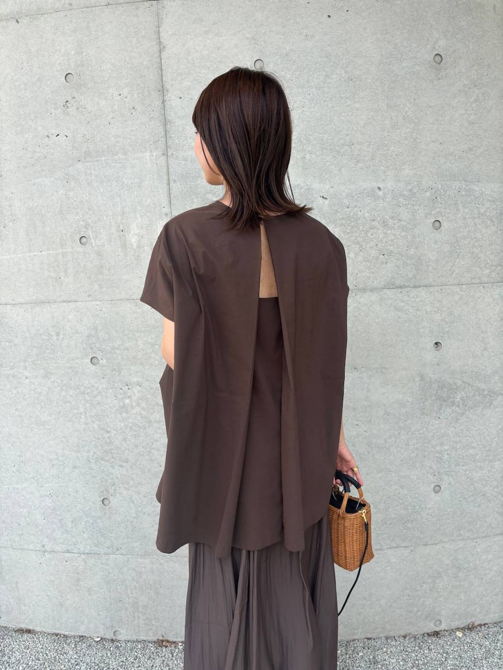 ブラック系のショルダーバッグ、ブラック系のサンダル、ブラウン系のスカートを着用したレディースの夏コーディネートの2枚目の写真