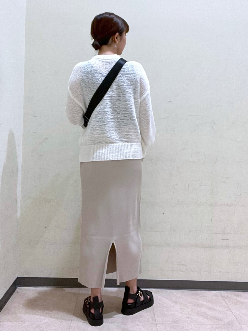 ホワイト系のショルダーバッグ、ホワイト系のニット/セーター、ブラック系のサンダルを着用したレディースの夏コーディネートの3枚目の写真