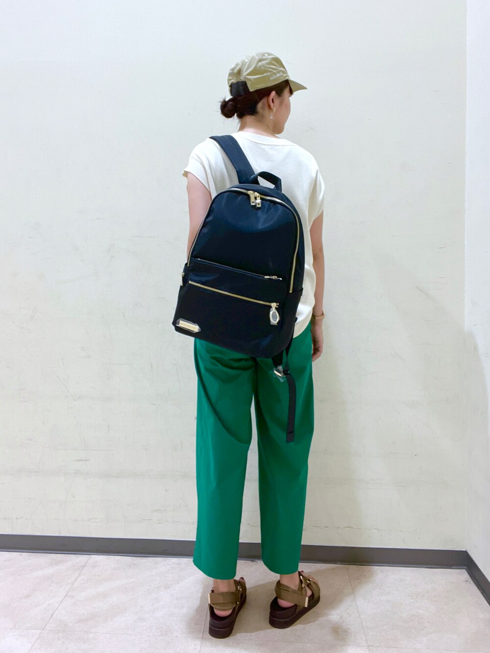 ホワイト系のニット/セーター、ブラック系のバックパック/リュック、グリーン系のその他パンツを着用したレディースの夏コーディネートの2枚目の写真
