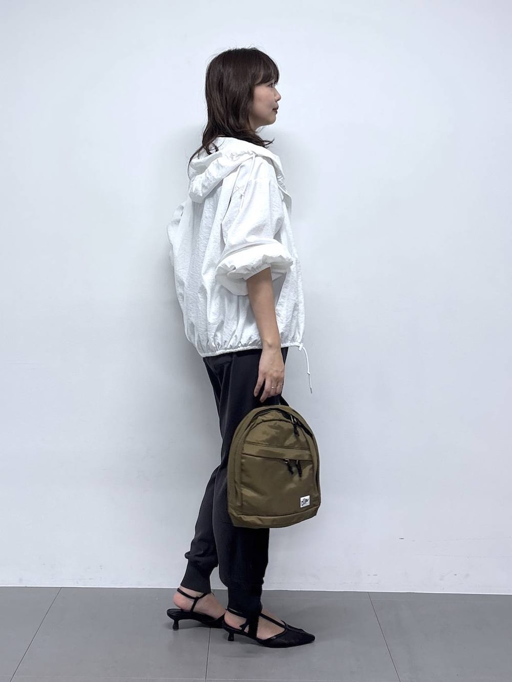 ホワイト系のブルゾン、ブラック系のパンプス、グレー系のその他パンツを着用したレディースの春コーディネートの2枚目の写真