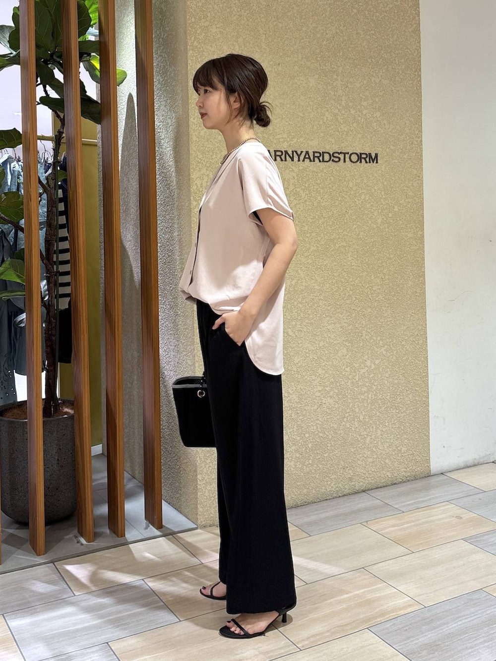 ブラック系のスラックス、ホワイト系のシャツ/ブラウス、ブラック系のトートバッグを着用したレディースの春コーディネートの3枚目の写真