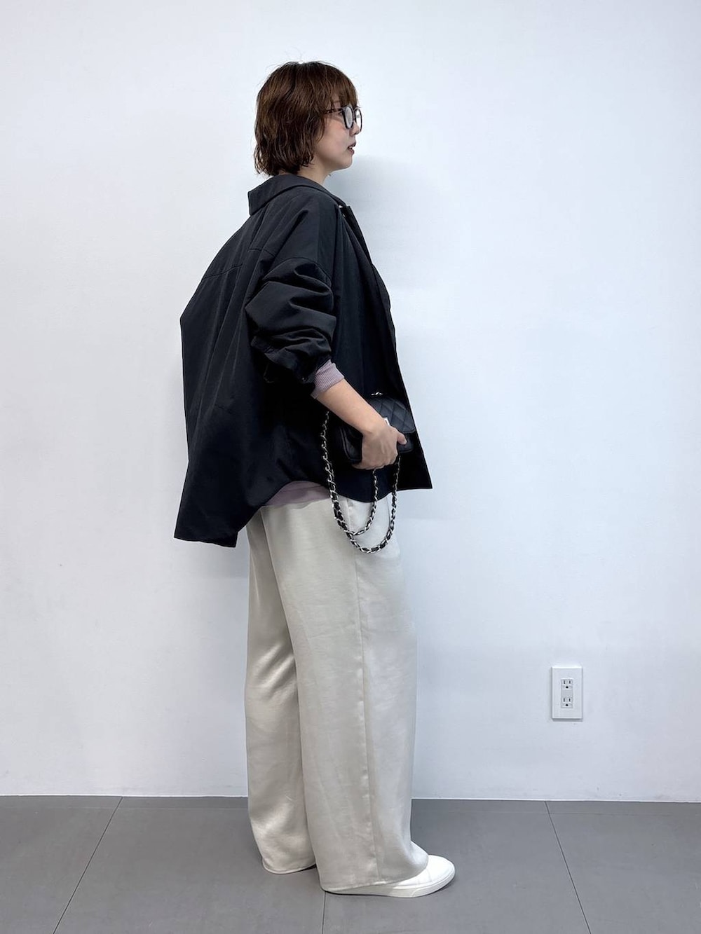 ピンク系のニット/セーター、ブラック系のハンドバッグ、ブラック系のブルゾンを着用したレディースの秋コーディネートの3枚目の写真