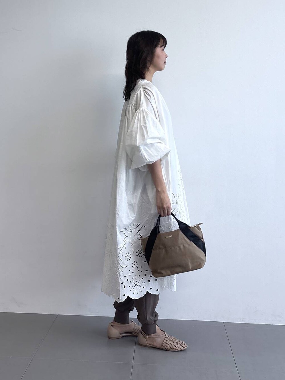 イエロー系のトートバッグ、ベージュ系のスリッポン、グリーン系のその他パンツを着用したレディースの春コーディネートの2枚目の写真