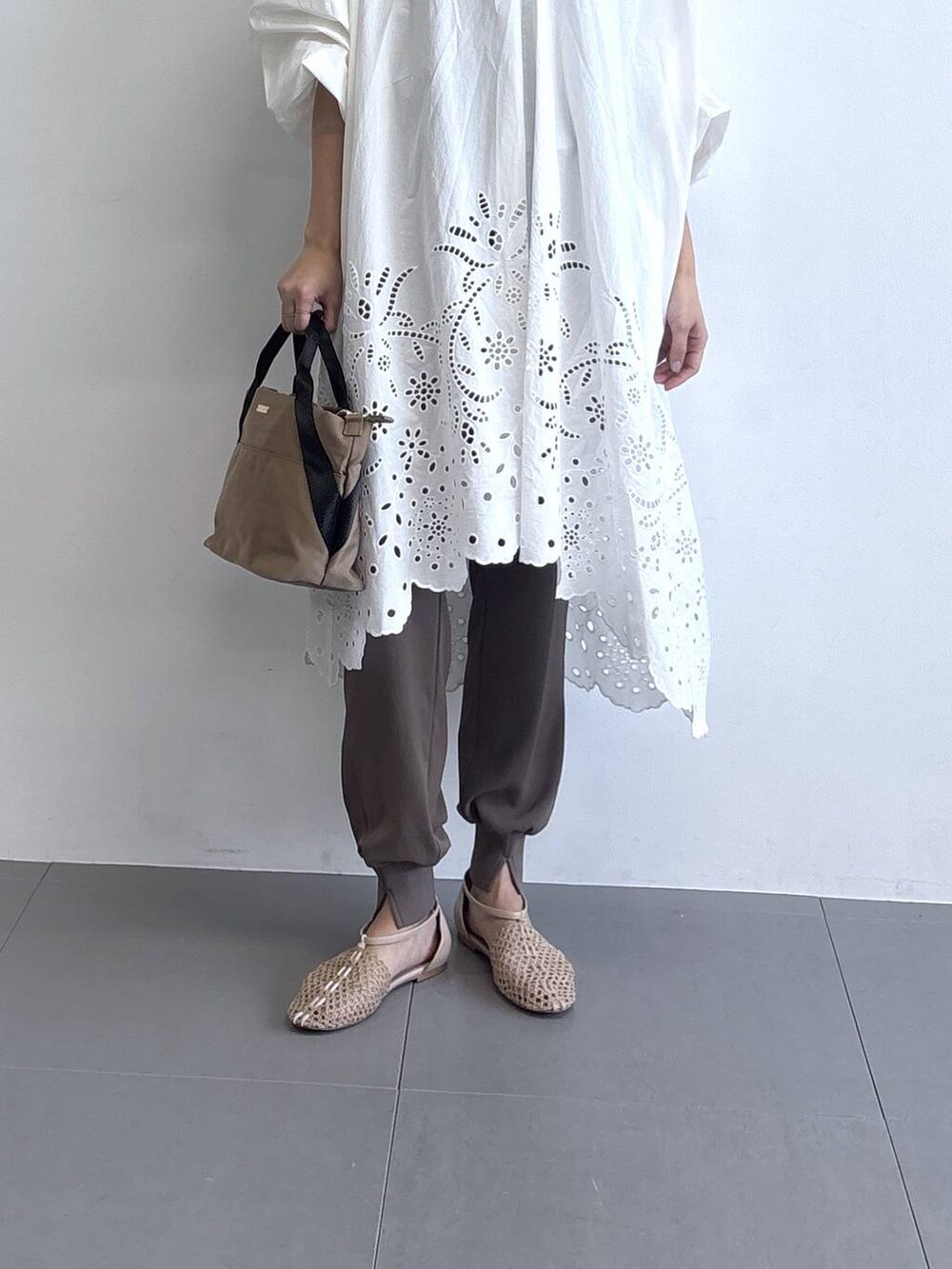 イエロー系のトートバッグ、ベージュ系のスリッポン、グリーン系のその他パンツを着用したレディースの春コーディネートの6枚目の写真