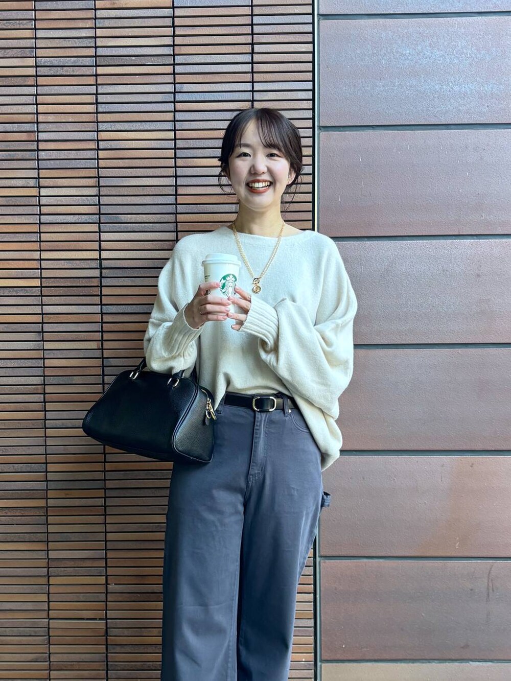 ブラック系のボストンバッグ、ホワイト系のニット/セーター、グレー系のその他パンツを着用したレディースの冬コーディネートの2枚目の写真