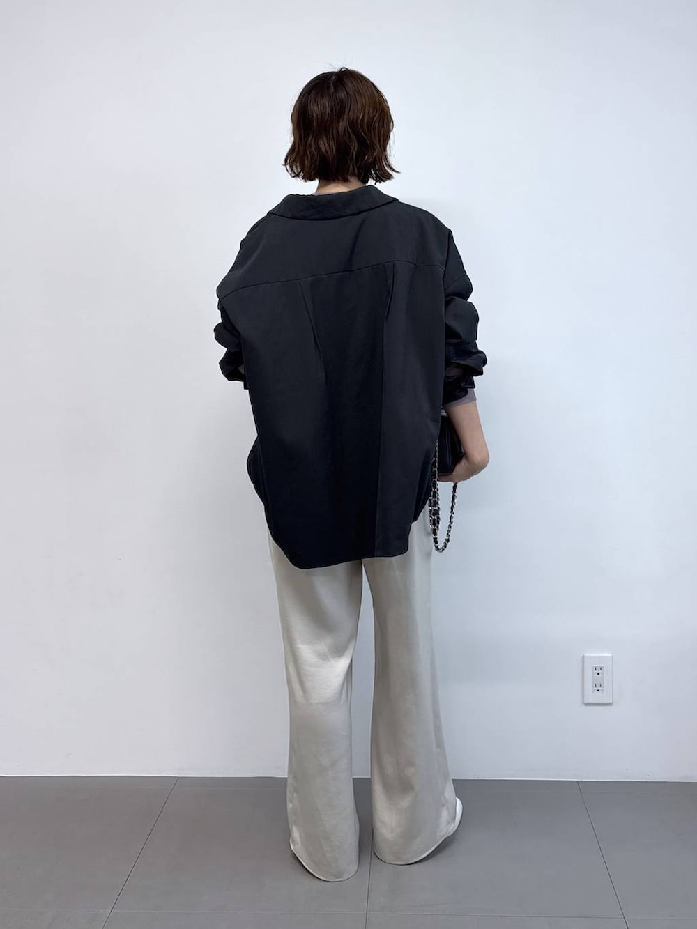 ピンク系のニット/セーター、ブラック系のハンドバッグ、ブラック系のブルゾンを着用したレディースの秋コーディネートの4枚目の写真