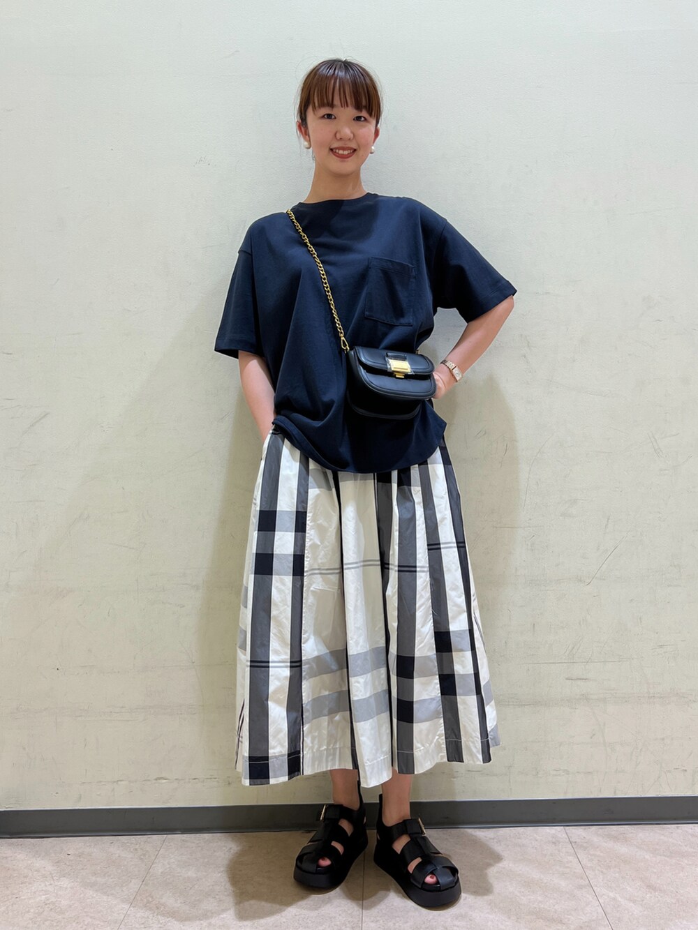 ブルー系のTシャツ/カットソー、ブラック系のボディバッグ/ウエストポーチ、ホワイト系のスカートを着用したレディースの夏コーディネートの2枚目の写真