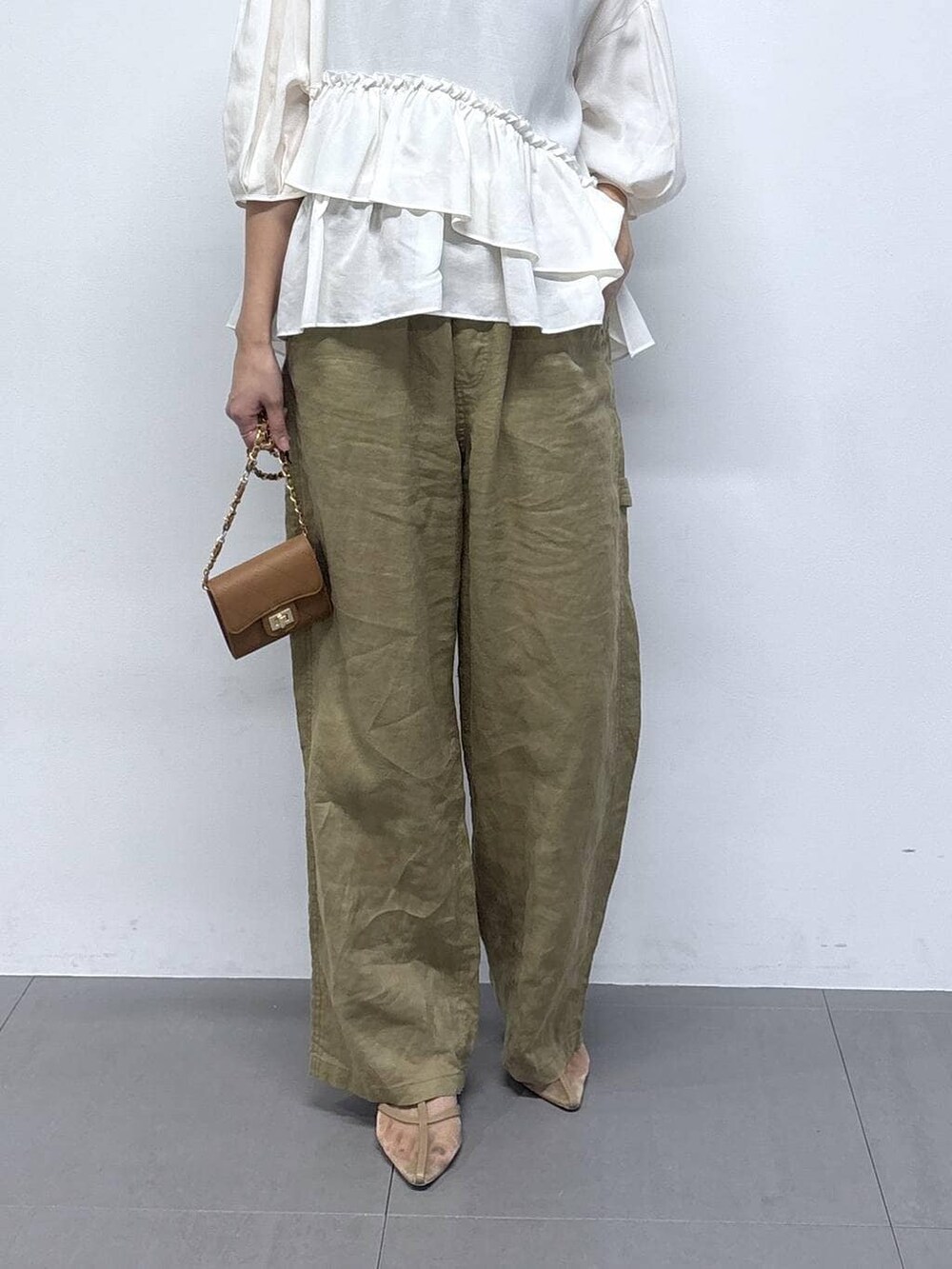 ベージュ系のその他パンツ、ベージュ系のパンプス、ベージュ系のショルダーバッグを着用したレディースの春コーディネートの4枚目の写真