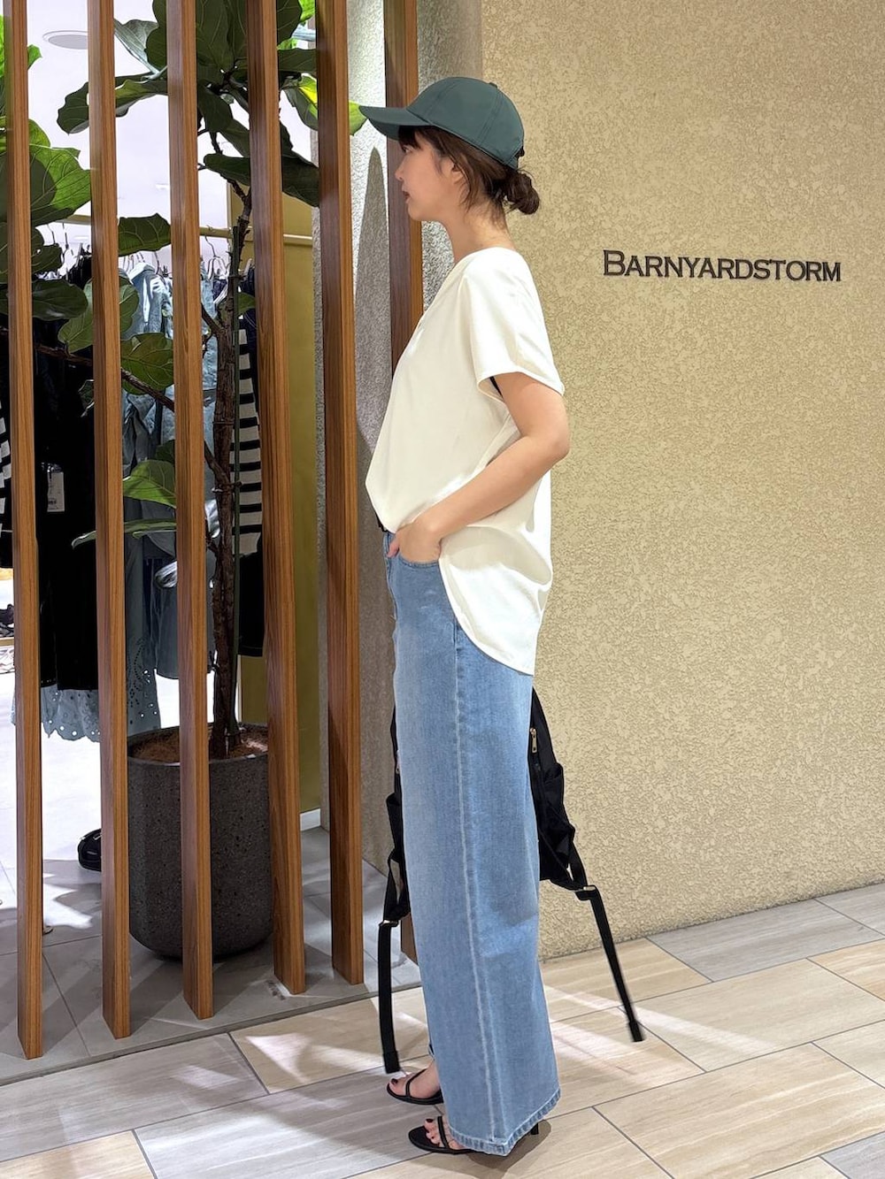 ブルー系のデニムパンツ、ブラック系のバックパック/リュック、ホワイト系のシャツ/ブラウスを着用したレディースの春コーディネートの2枚目の写真