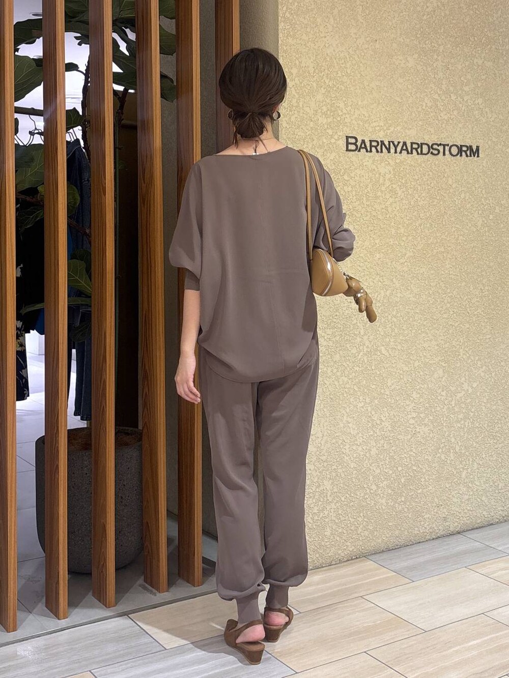 グリーン系のTシャツ/カットソー、ブラウン系のハンドバッグ、イエロー系のパンプスを着用したレディースの冬コーディネートの5枚目の写真